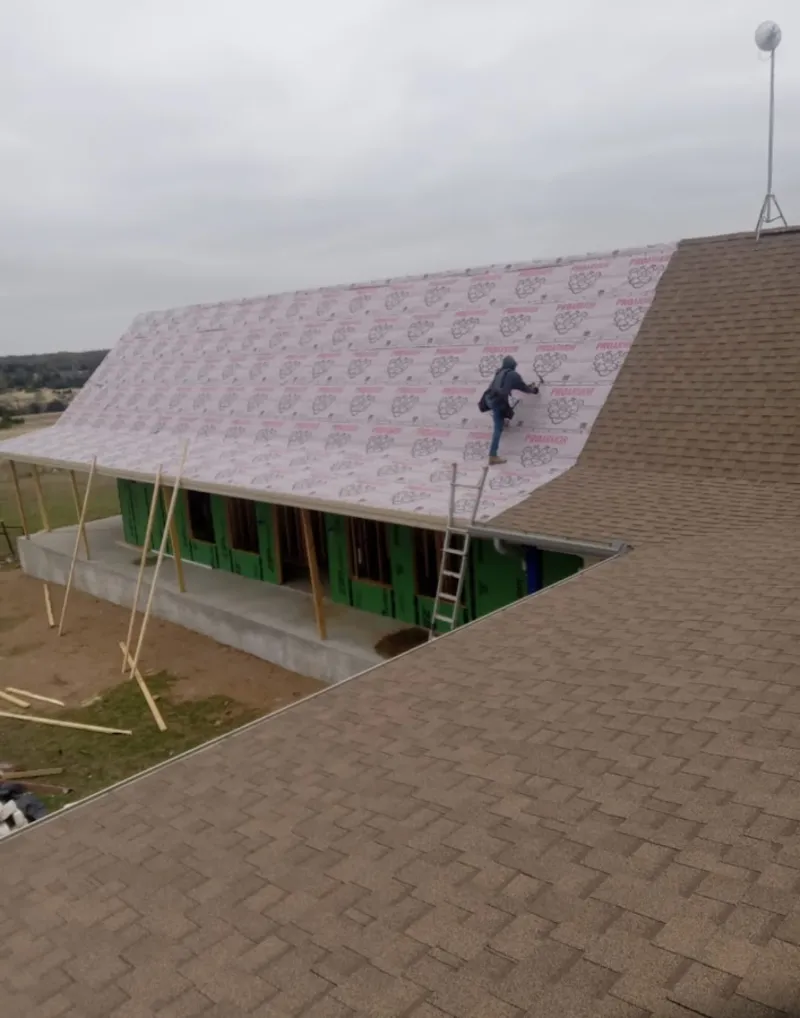 Worker preparing underlayment for a metal roof installation in Kentfield